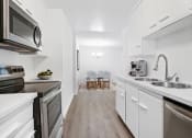 Thumbnail 3 of 40 - a kitchen with white cabinets and stainless steel appliances and a sink