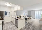 Thumbnail 2 of 24 - A modern kitchen with a refrigerator on the left and a dining area with a white couch and a coffee table.
