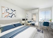 Thumbnail 5 of 24 - A bedroom with a large bed and a painting on the wall.