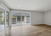 Thumbnail 100 of 135 - A room with a sliding glass door leading to a balcony.