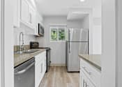 Thumbnail 97 of 135 - A modern kitchen with white cabinets and stainless steel appliances.