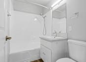 Thumbnail 102 of 135 - A white bathroom with a toilet, sink, and bathtub.