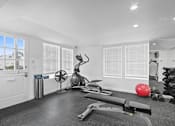 Thumbnail 134 of 135 - A room with a row of windows covered in blinds, a fan, a rowing machine, and a red ball.