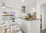 Thumbnail 25 of 135 - a white kitchen with a bar and a dining area