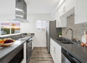 Thumbnail 24 of 135 - a kitchen with stainless steel appliances and a bowl of fruit on the counter