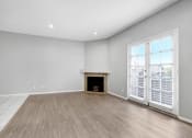 Thumbnail 21 of 62 - an empty living room with a fireplace and wooden floors