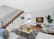 Thumbnail 6 of 24 - a living room with white furniture and a staircase in the background