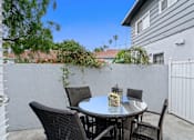 Thumbnail 11 of 24 - a patio with a table and chairs in front of a house