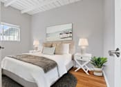 Thumbnail 7 of 24 - a bedroom with a bed and a white table with two lamps