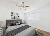Thumbnail 15 of 19 - A bedroom with a large bed and a ceiling fan.