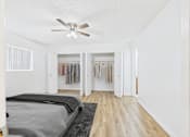 Thumbnail 16 of 19 - A bedroom with a bed, a ceiling fan, and a wardrobe.