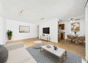 Thumbnail 13 of 19 - A modern living room with a grey sofa, a wooden coffee table, and a flat-screen TV.