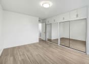 Thumbnail 16 of 19 - an empty room with white walls and mirrored closet doors