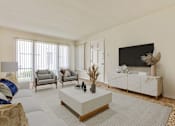 Thumbnail 2 of 11 - A living room with a white sofa, grey armchairs, a white coffee table, and a black television.