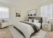 Thumbnail 3 of 11 - A bedroom with a large bed, a white armchair, and two framed pictures on the wall.