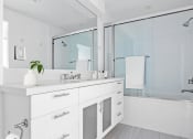 Thumbnail 8 of 86 - a white bathroom with a large mirror and a sink and a shower