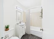 Thumbnail 33 of 43 - A white bathroom with a toilet, sink, and shower.