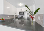 Thumbnail 3 of 21 - a kitchen with white cabinets and a vase with a plant