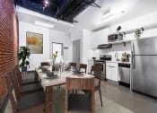 Thumbnail 11 of 45 - a dining room with a table and chairs and a kitchen in the background