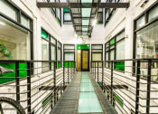 Thumbnail 14 of 45 - a corridor in a building with a glass floor and metal railings
