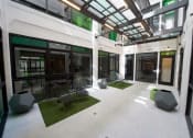 Thumbnail 29 of 45 - Downtown Los Angeles, CA, Apartments - Broadway Lofts - Outdoor Courtyard with Chairs, Turf Grass Mats, And Pots.