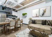 Thumbnail 2 of 45 - a living area with a couch table and chairs and a kitchen in the background