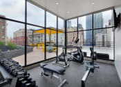 Thumbnail 33 of 45 - a gym with floor to ceiling windows and a view of a city