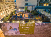 Thumbnail 37 of 45 - Downtown Los Angeles Apartments - Broadway Lofts - Rooftop Area With City Views, BBQ Area, Lounge Chairs, Gym, And Garden.