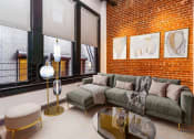 Thumbnail 10 of 45 - Apartments In Downtown Los Angeles, CA, for Rent - Broadway Lofts - Loft Style Living Room With High Ceilings, Exposed Brick Walls, Concrete Columns, And Floor-To-Ceilings Windows.