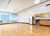 Thumbnail 33 of 37 - Downtown Los Angeles, CA Apartments for Rent - Mercantile Lofts - Open Concept Kitchen With Stainless Steel Appliances, Wood Cabinetry, Hardwood Floors, And Oversized Windows With City Views.