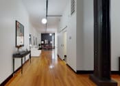 Thumbnail 19 of 37 - a long hallway with hardwood floors and white walls