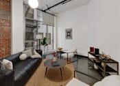 Thumbnail 25 of 37 - a living room with a leather couch and a coffee table in front of a window