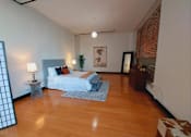Thumbnail 26 of 37 - Dog-Friendly Apartments In Downtown Los Angeles, CA - Mercantile Lofts - Spacious Living Area With Bamboo Wood Flooring, High Ceilings, Contemporary Lighting Fixtures, And Exposed Brick Wall.