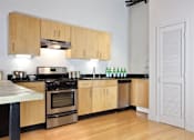 Thumbnail 34 of 37 - a kitchen with wooden cabinets and a stove top oven