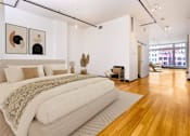 Thumbnail 8 of 37 - a bedroom with a large bed and a hardwood floor