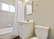 Thumbnail 14 of 17 - Bathroom with Single round vanity, white cabinet, tub and shower combo with light gray wall tiles