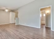 Thumbnail 15 of 17 - Living room wood-style floors throughout the unit, dining area with ceiling fan on the left