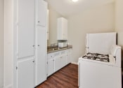 Thumbnail 17 of 17 - Kitchen With White Appliances, Refrigerator, Gas Range, Microwave, Stainless double kitchen sink with granite countertops, White kitchen cabinets, wood-style flooring