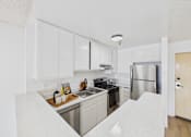 Thumbnail 26 of 46 - A kitchen with white cabinets and stainless steel appliances.