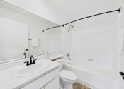 Thumbnail 37 of 46 - A white bathroom with a toilet, sink, and bathtub.