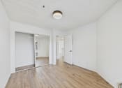 Thumbnail 35 of 46 - A room with white walls and wooden flooring.