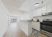 Thumbnail 27 of 46 - A kitchen with a white island and stove top oven.