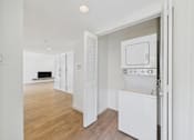 Thumbnail 109 of 135 - A white oven and microwave are in a kitchen with wooden floors.