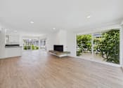 Thumbnail 106 of 135 - A spacious living room with a fireplace and sliding glass doors.