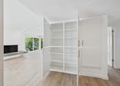 Thumbnail 110 of 135 - A white shelving unit is open in a room with wood flooring.