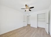 Thumbnail 117 of 135 - A room with a ceiling fan and light fixture, two doors, and a windowless wall.