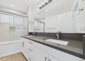 Thumbnail 119 of 135 - A modern bathroom with a large mirror and a sink.