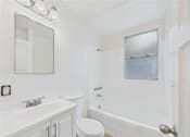 Thumbnail 11 of 21 - A white bathroom with a toilet, sink, and bathtub.