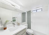 Thumbnail 15 of 115 - A white bathroom with a toilet, sink, and bathtub.