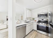 Thumbnail 11 of 115 - A modern kitchen with stainless steel appliances and white cabinetry.